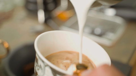 cream being poured into a coffee cup.